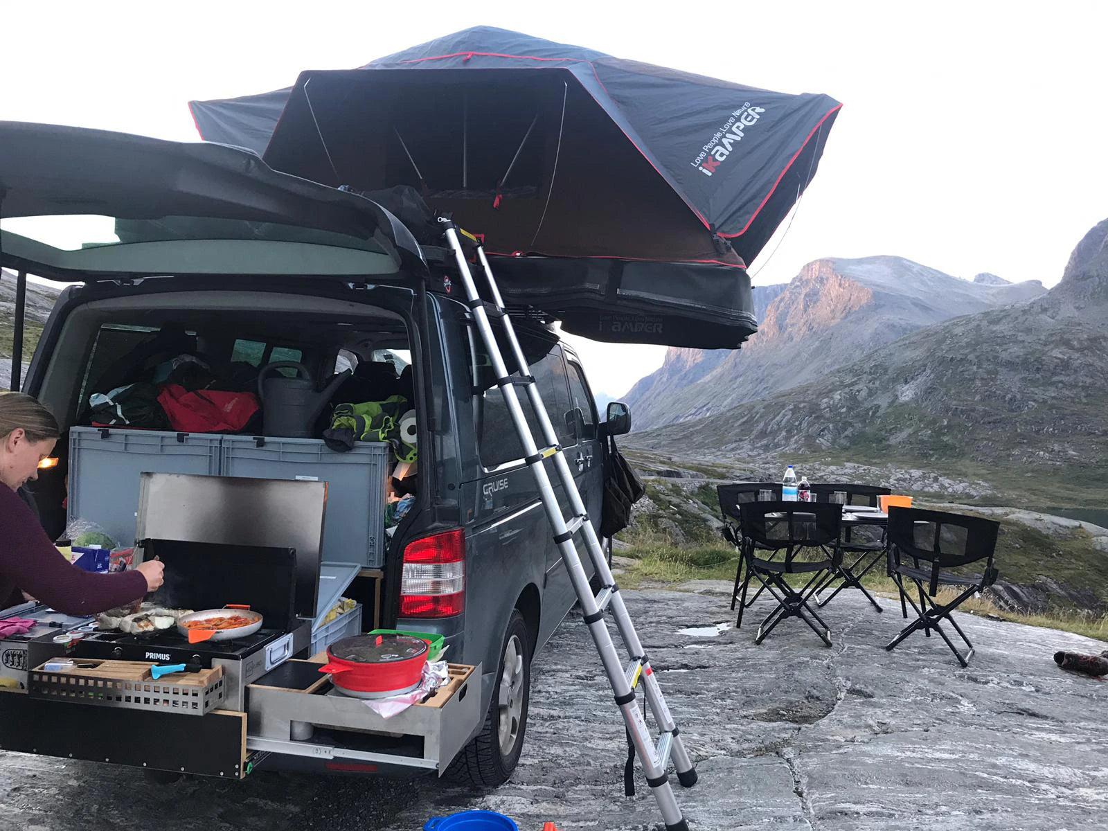Mobile Küchenbox MOKUBO quer auf Heckauszug im VW Bus vor Berg Panorama